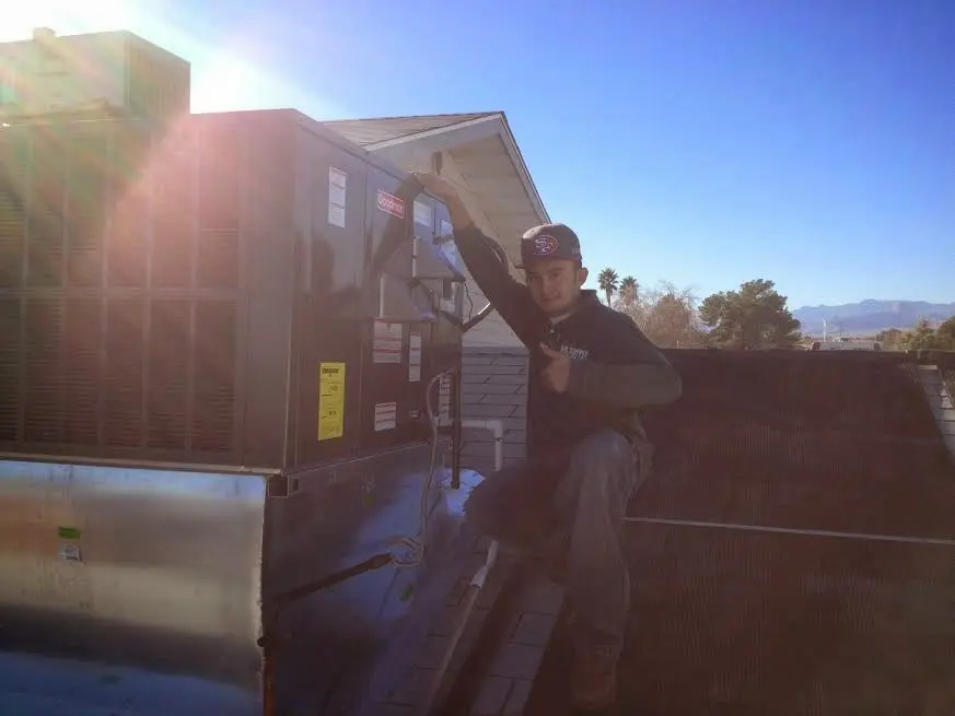 HVAC technician performing Boiler Repair on a rooftop unit in Harrisburg