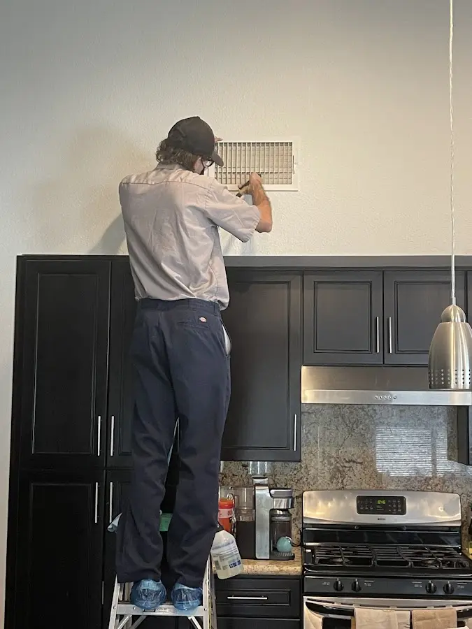 Technician inspecting an air vent during HVAC service in Harrisburg